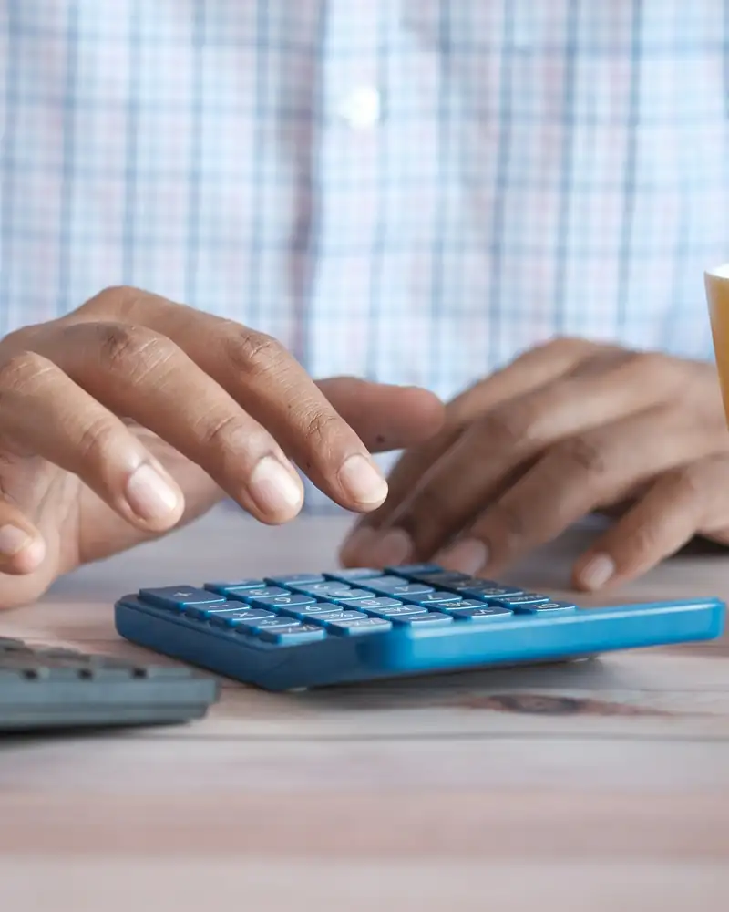 Manos usando una calculadora sobre un escritorio
